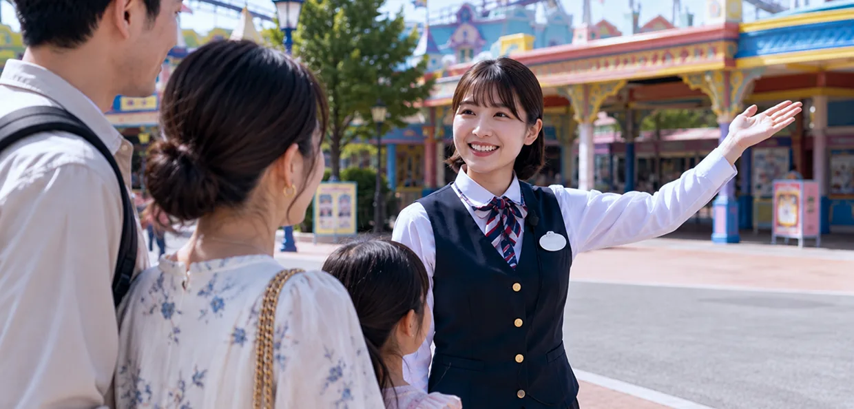 テーマパークで家族連れを案内するスタッフ